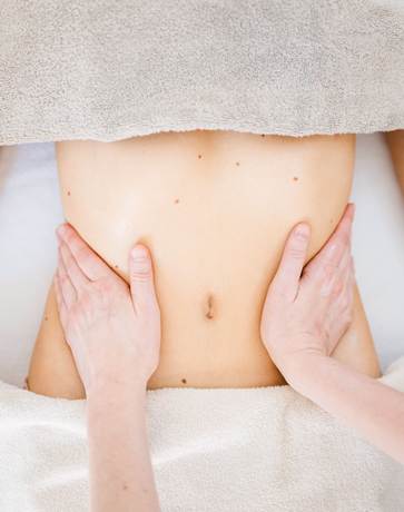 Die brasilianische Lymphmodellage Eine Frau bekommt eine Bauschmassage,