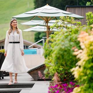 Eine Frau spaziert über die Terrasse der Hotel Juffing.