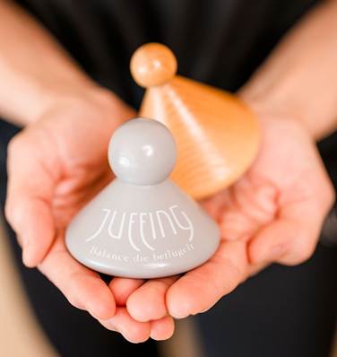 Faszien können ihre Elstizität verlieren und sogar verkleben Eine Frau hält kleine Kegel in den Händen, die zur Faszienmassage verwendet werden.